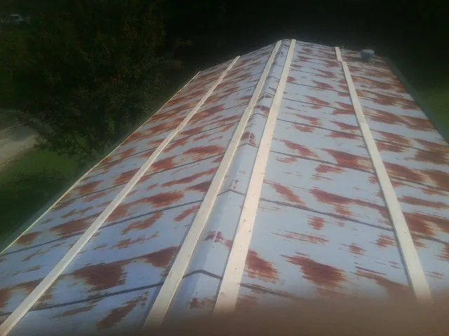 Rusted metal roof panels with new wood purlins before replacement — Storm Damage Roof Repair in Benzonia by Roofing Brothers